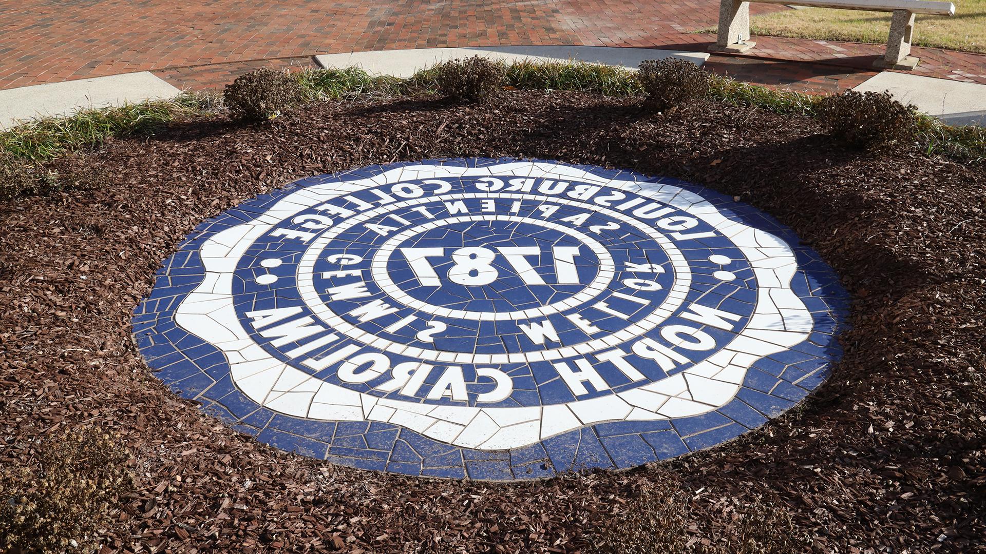 Image of the College Seal by the Main Building.